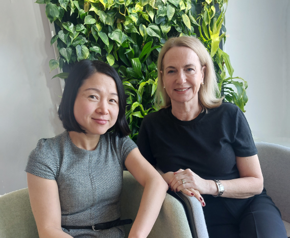 En bild av två personer som sitter i varsin fåtölj och ler mot kameran