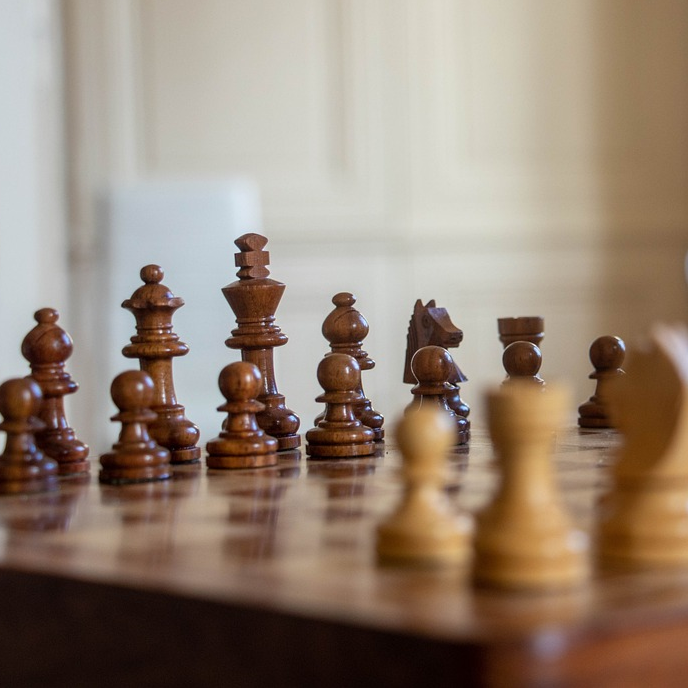 Schackbräde med träpjäser i ett pågående parti.